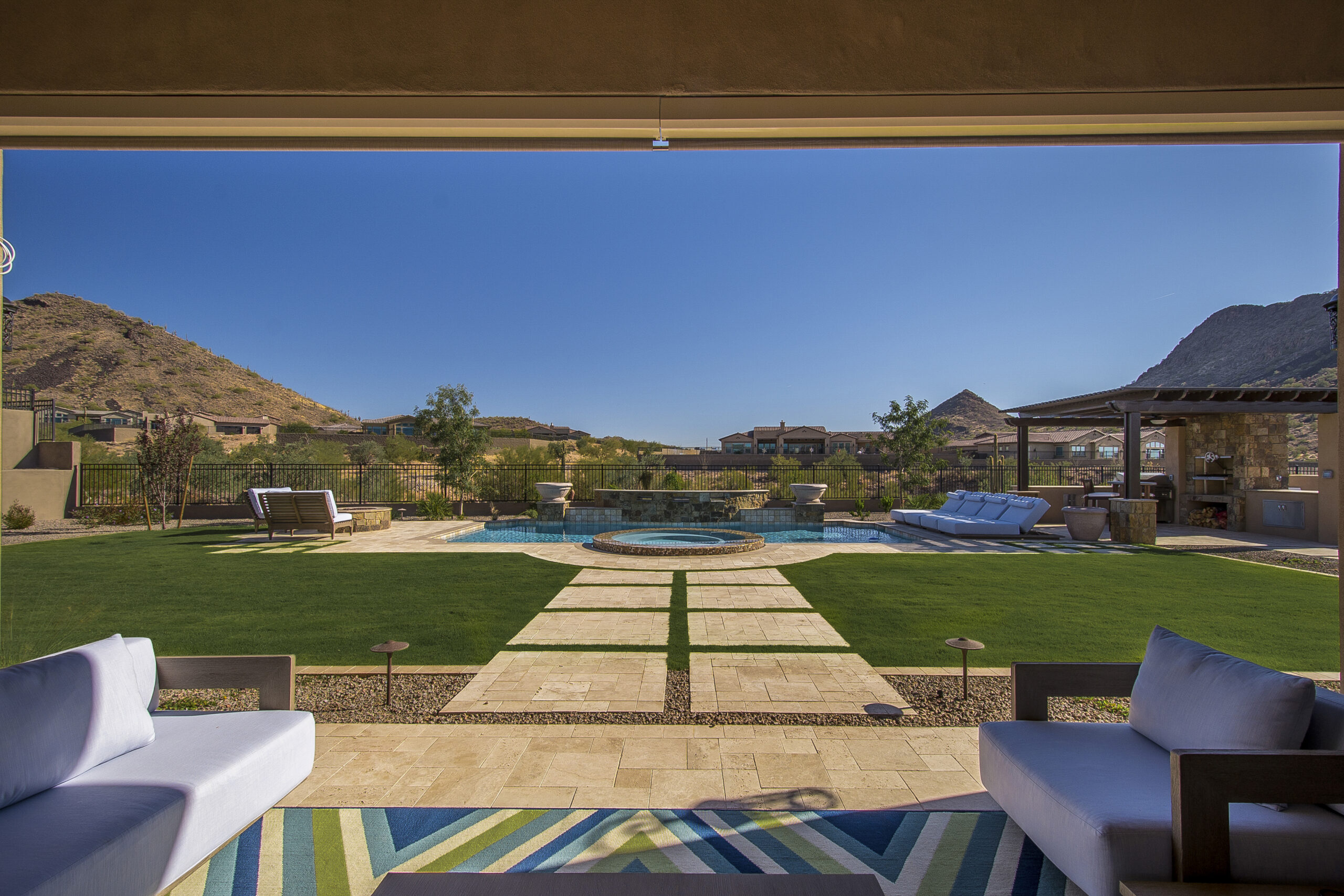 a patio with a pool and a lawn