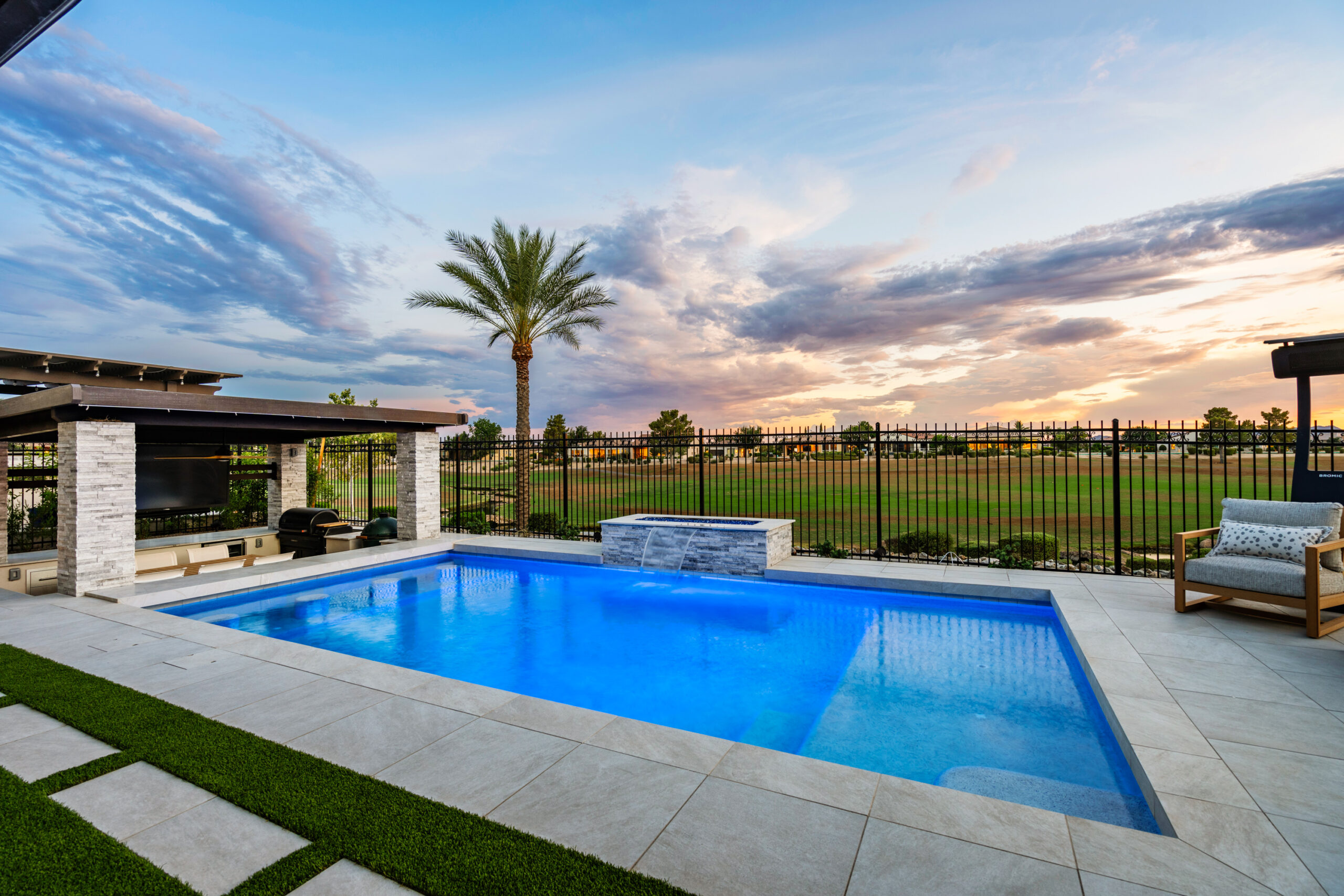 a pool with grass and a fence