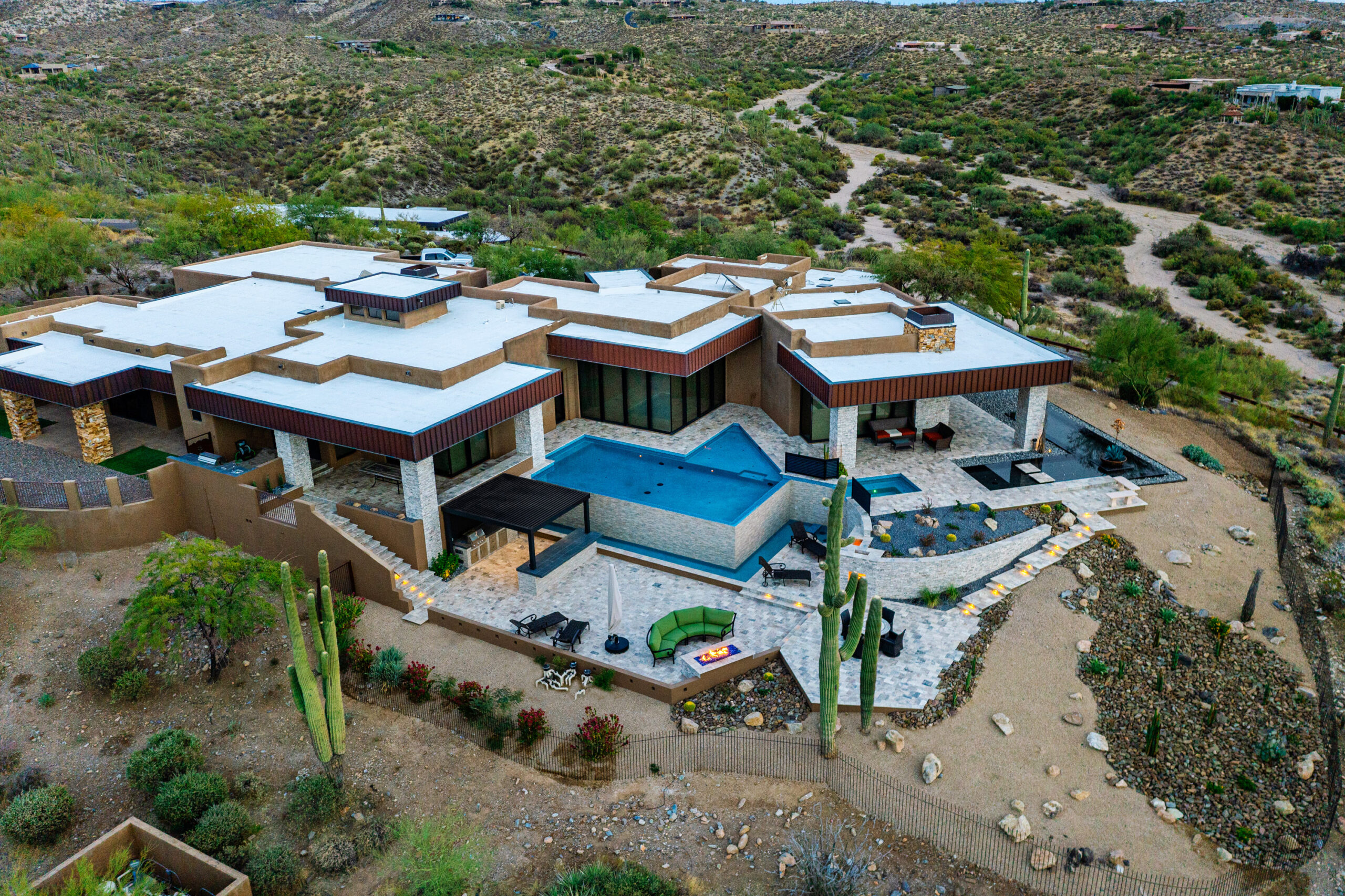 a large house with a pool in the middle of a desert