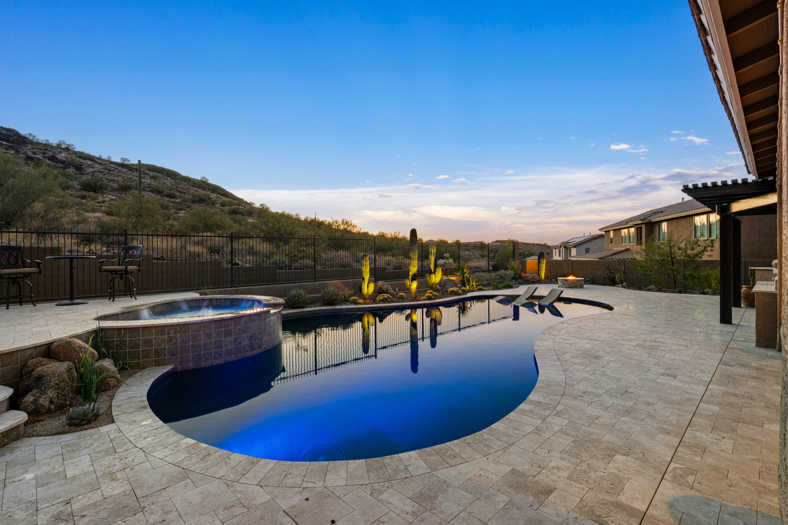 a pool with a hot tub and a hot tub in the back