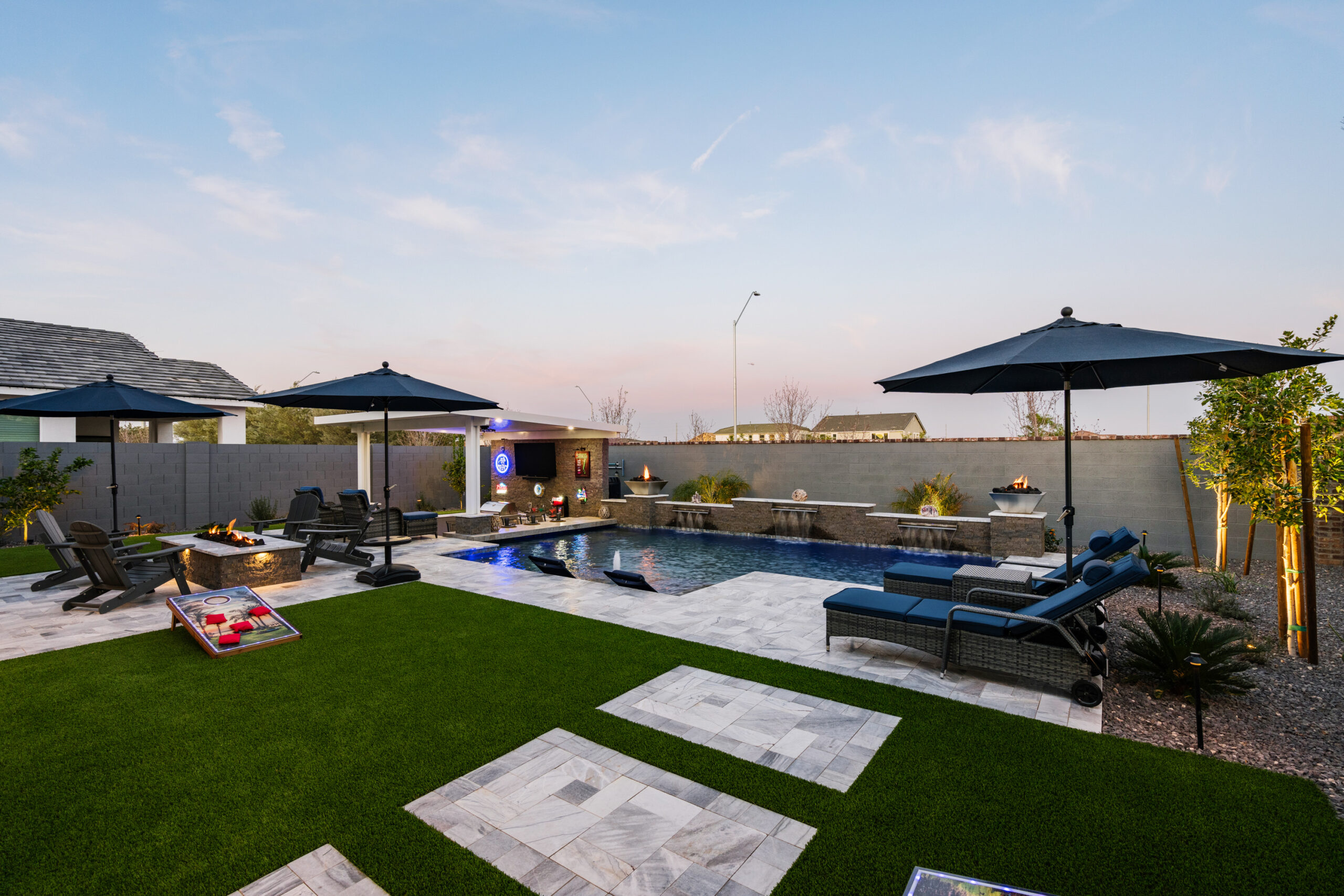 a pool with a fire pit and umbrellas