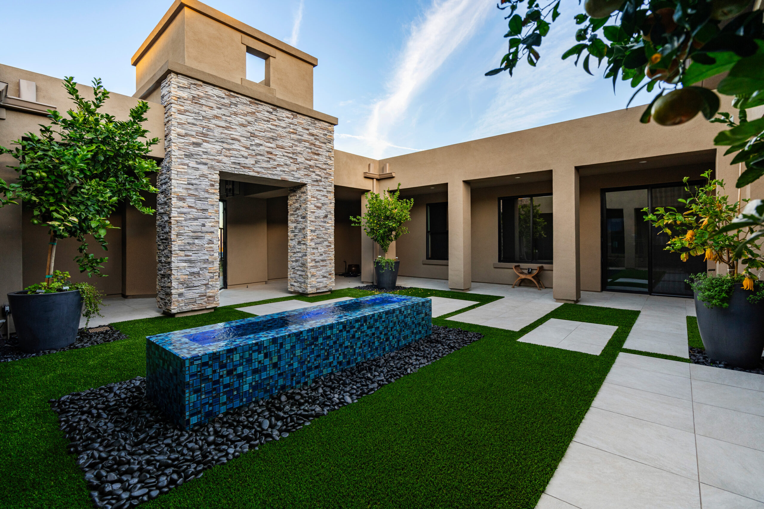 a courtyard with a fountain and a stone wall