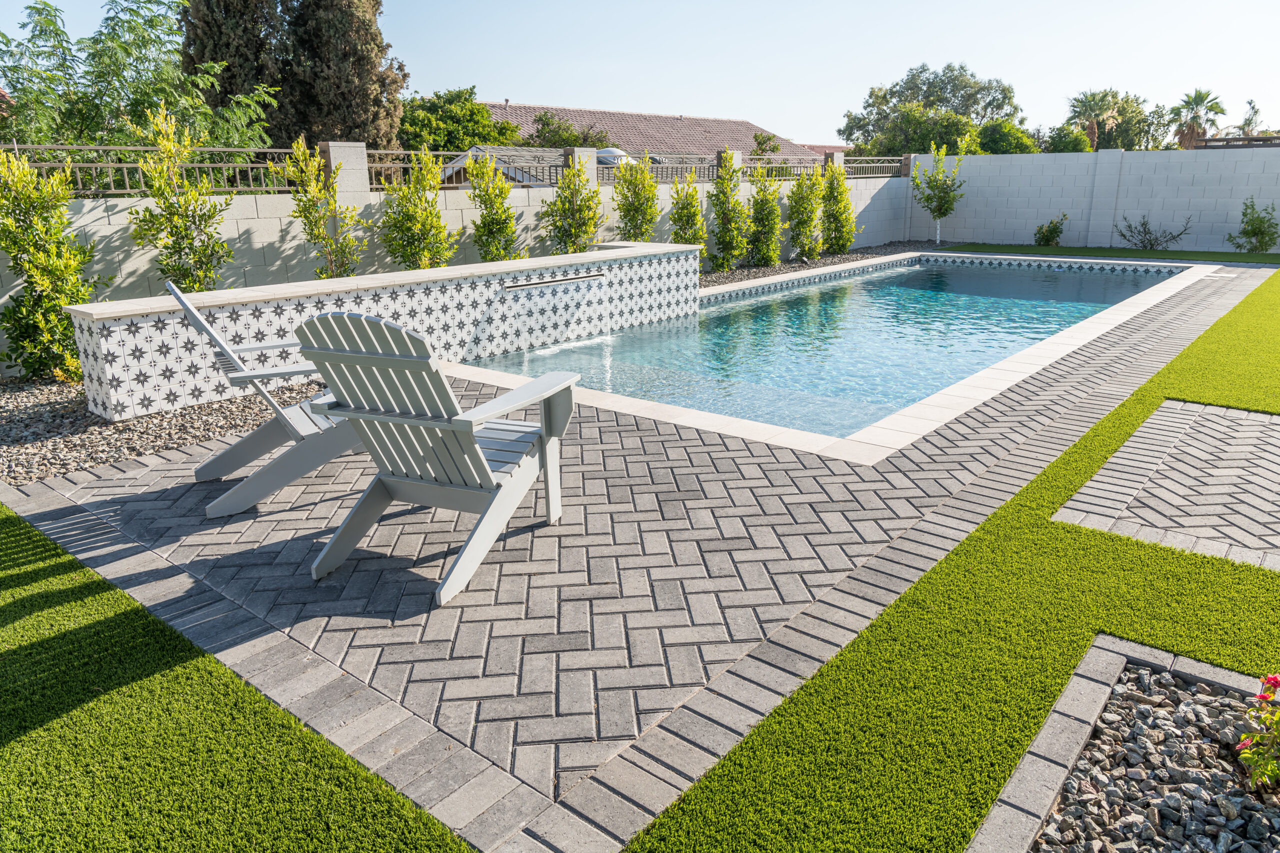 a pool with lawn chairs and grass