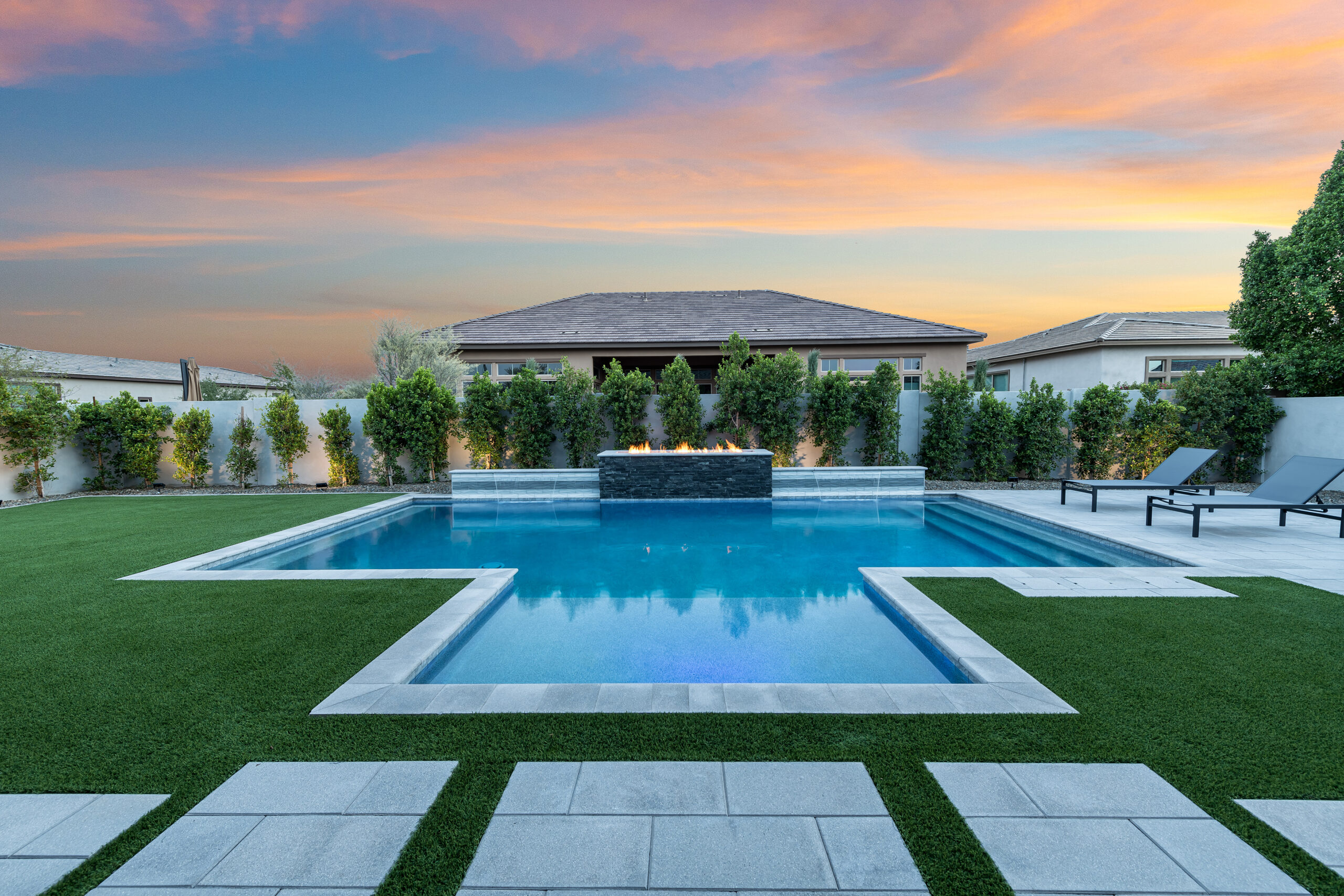 a pool with a fire fountain in the middle of a yard