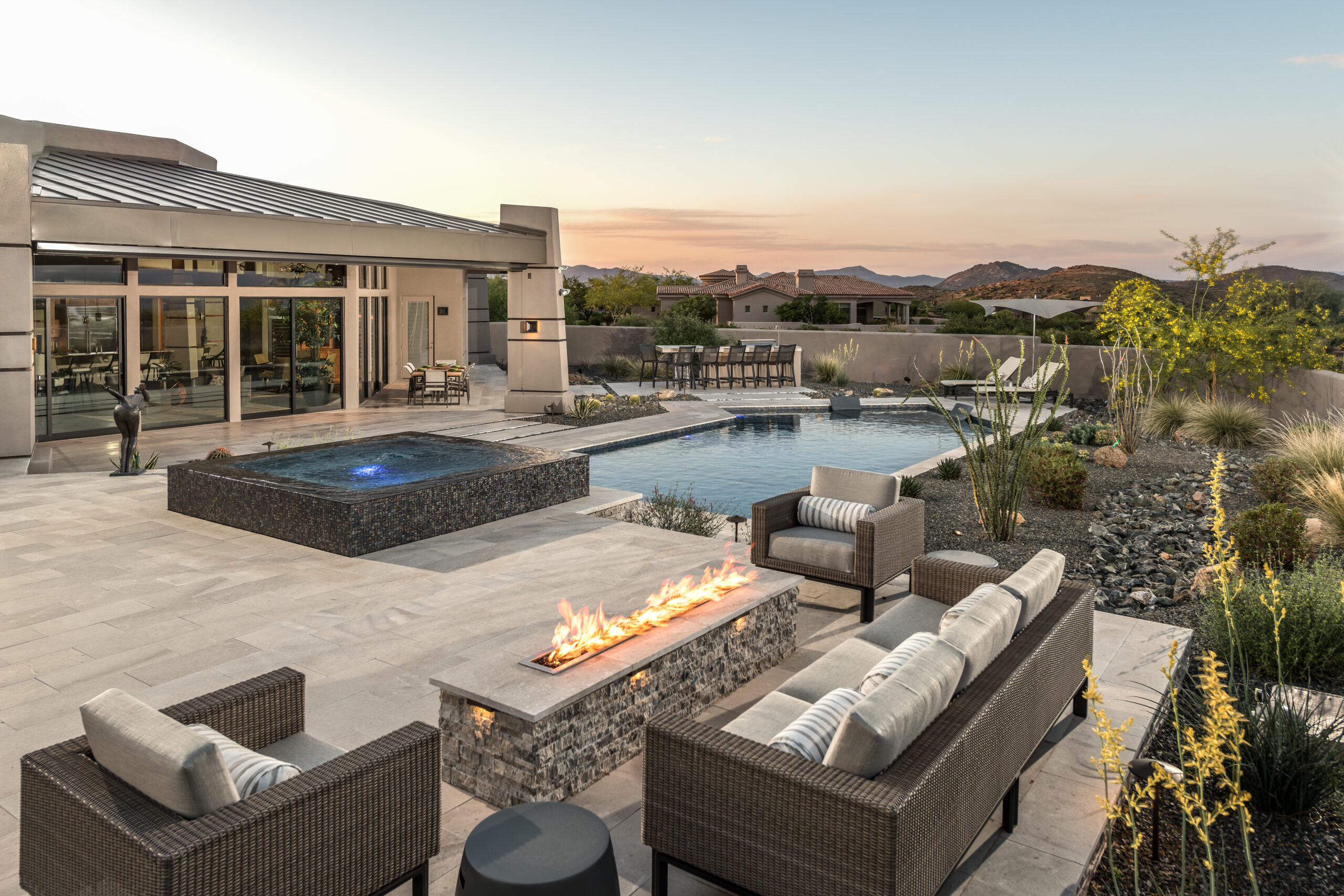 a patio with a fire pit and a pool